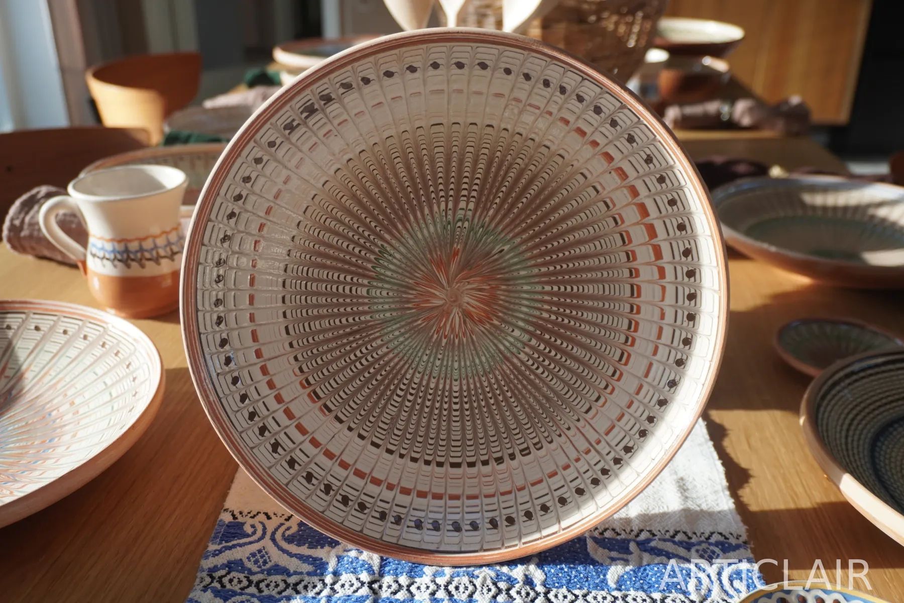 A Horezu ceramic plate with a dense hand-painted radial pattern in warm earth tones
