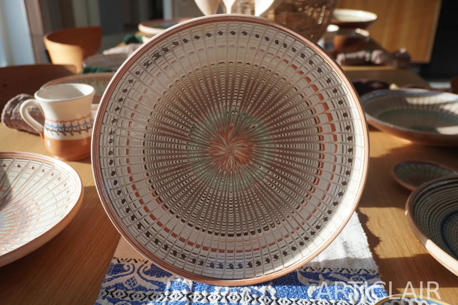 A Horezu ceramic plate with a dense hand-painted radial pattern in warm earth tones