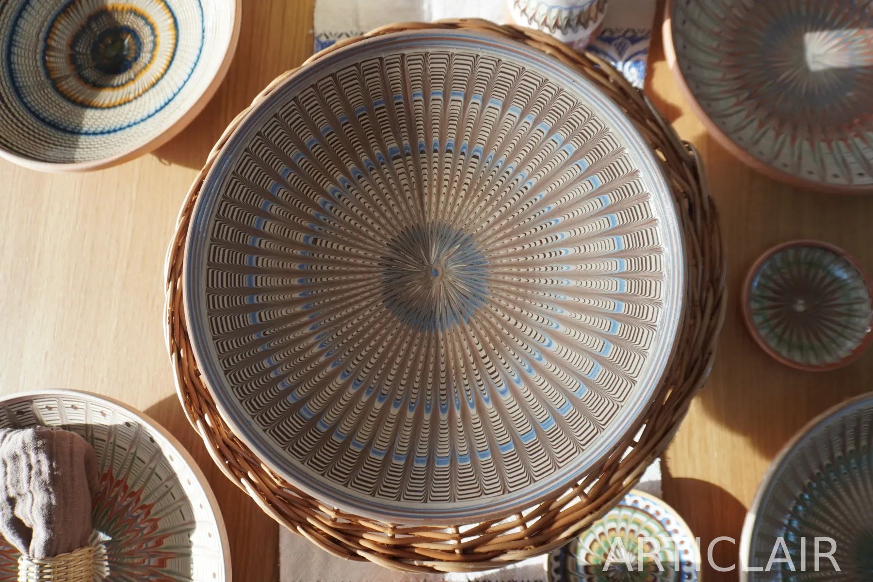 A pale Horezu plate with blue rings placed among other ceramic pieces