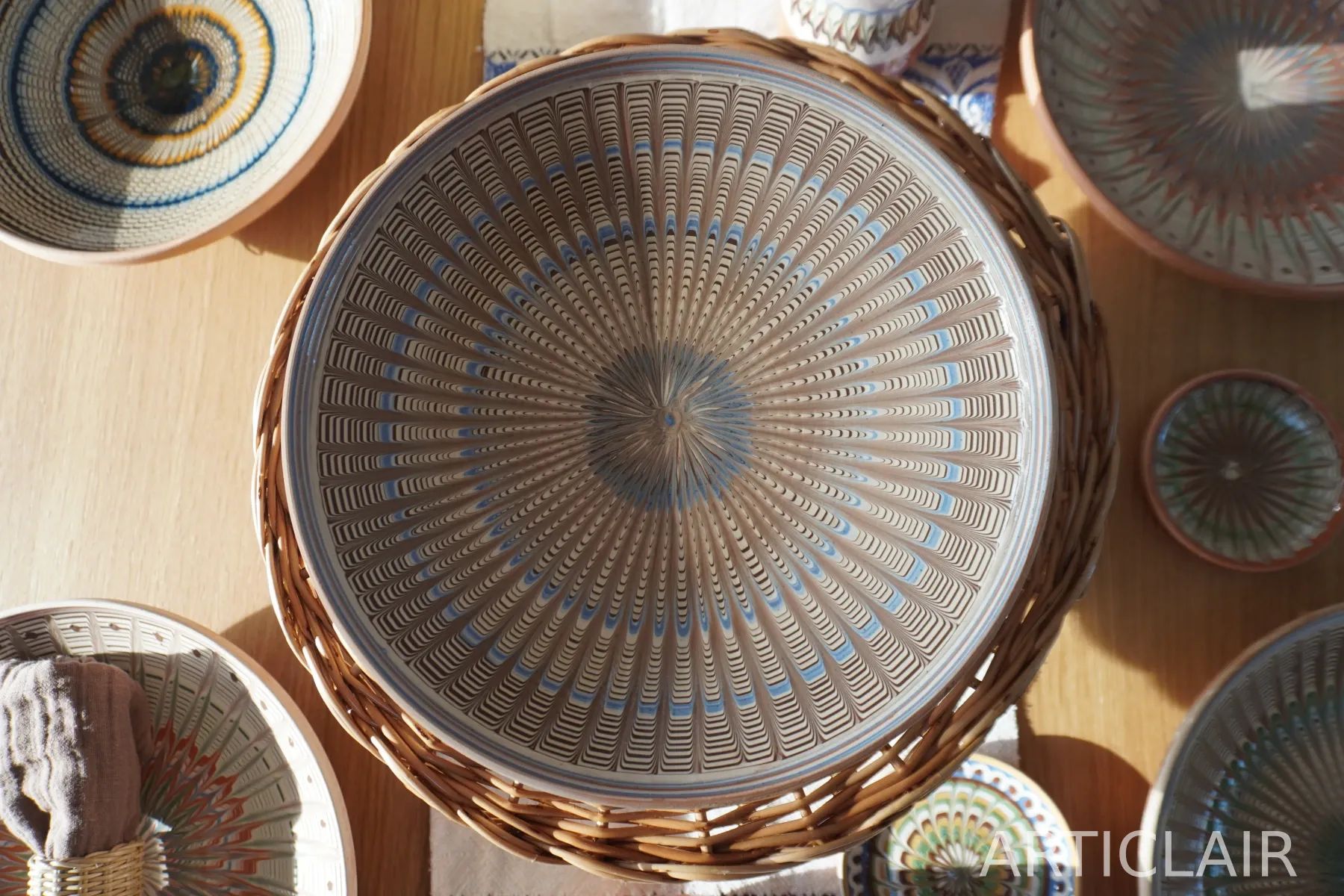 A pale Horezu plate with blue rings placed among other ceramic pieces