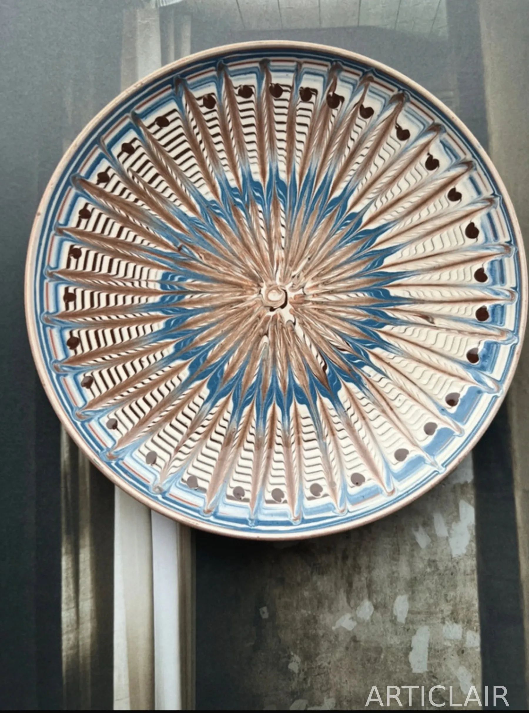 A Horezu display plate with blue radial rays and dark accent dots