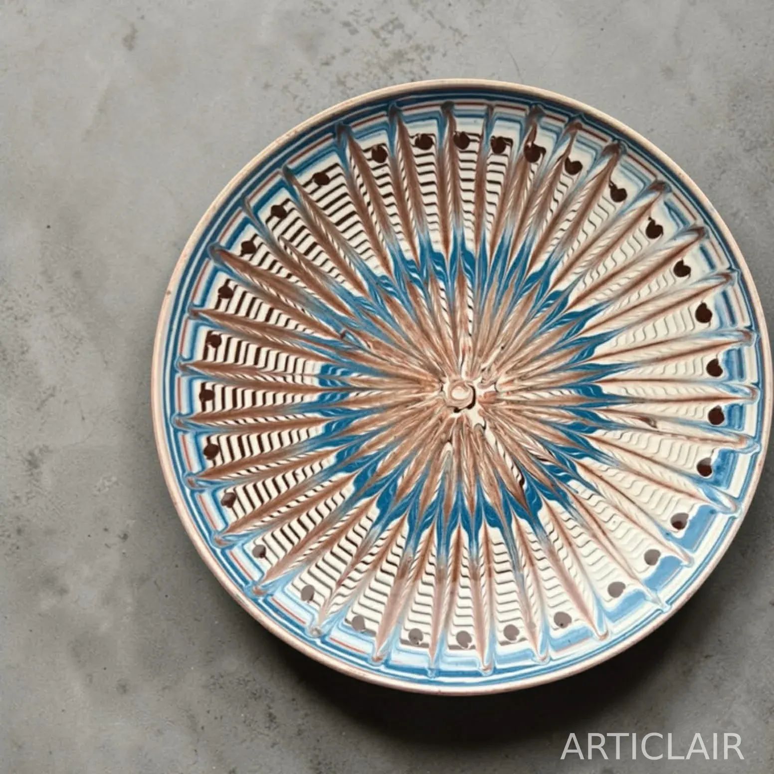 A Horezu display plate with blue radial rays and dark accent dots