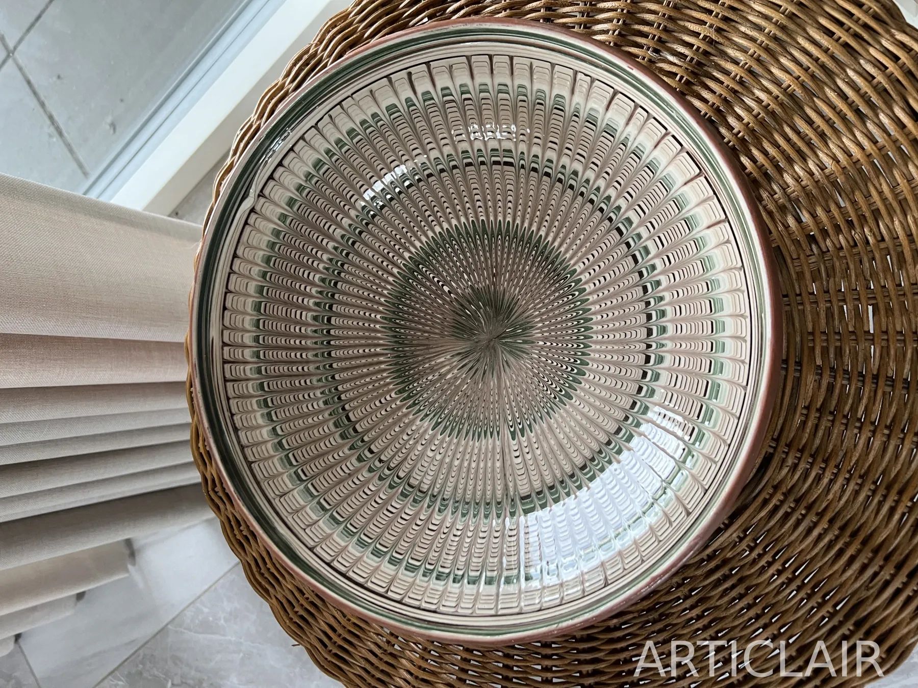 A pale ceramic plate with green spiral-like rings and a dense radial surface