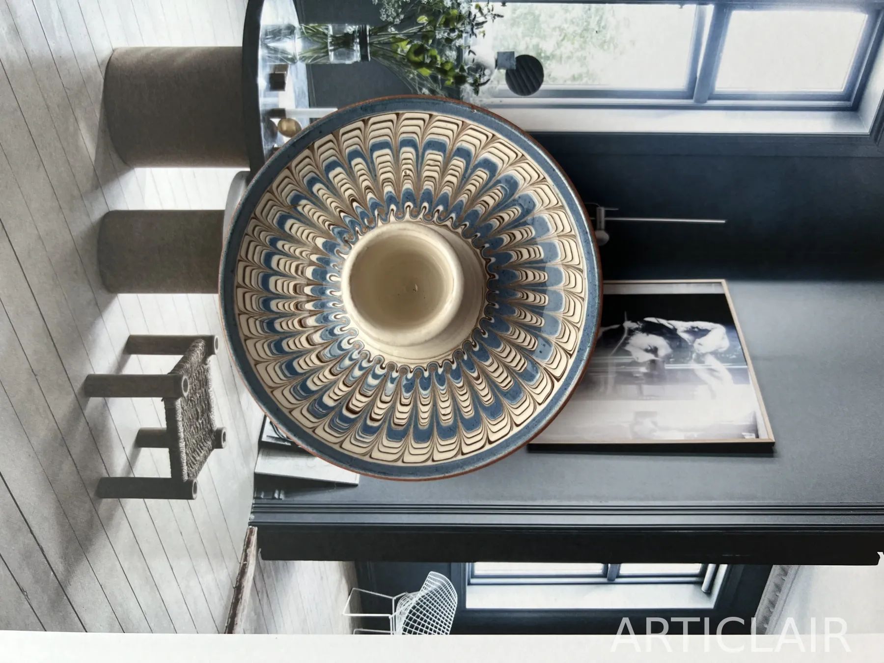 A large Horezu serving bowl with blue feathered decoration in a dark interior setting