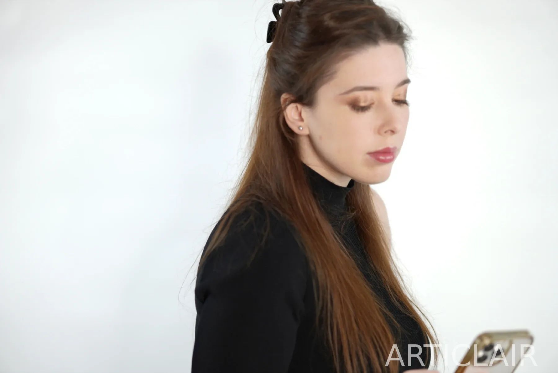 A side-profile portrait with a phone resting in the hand