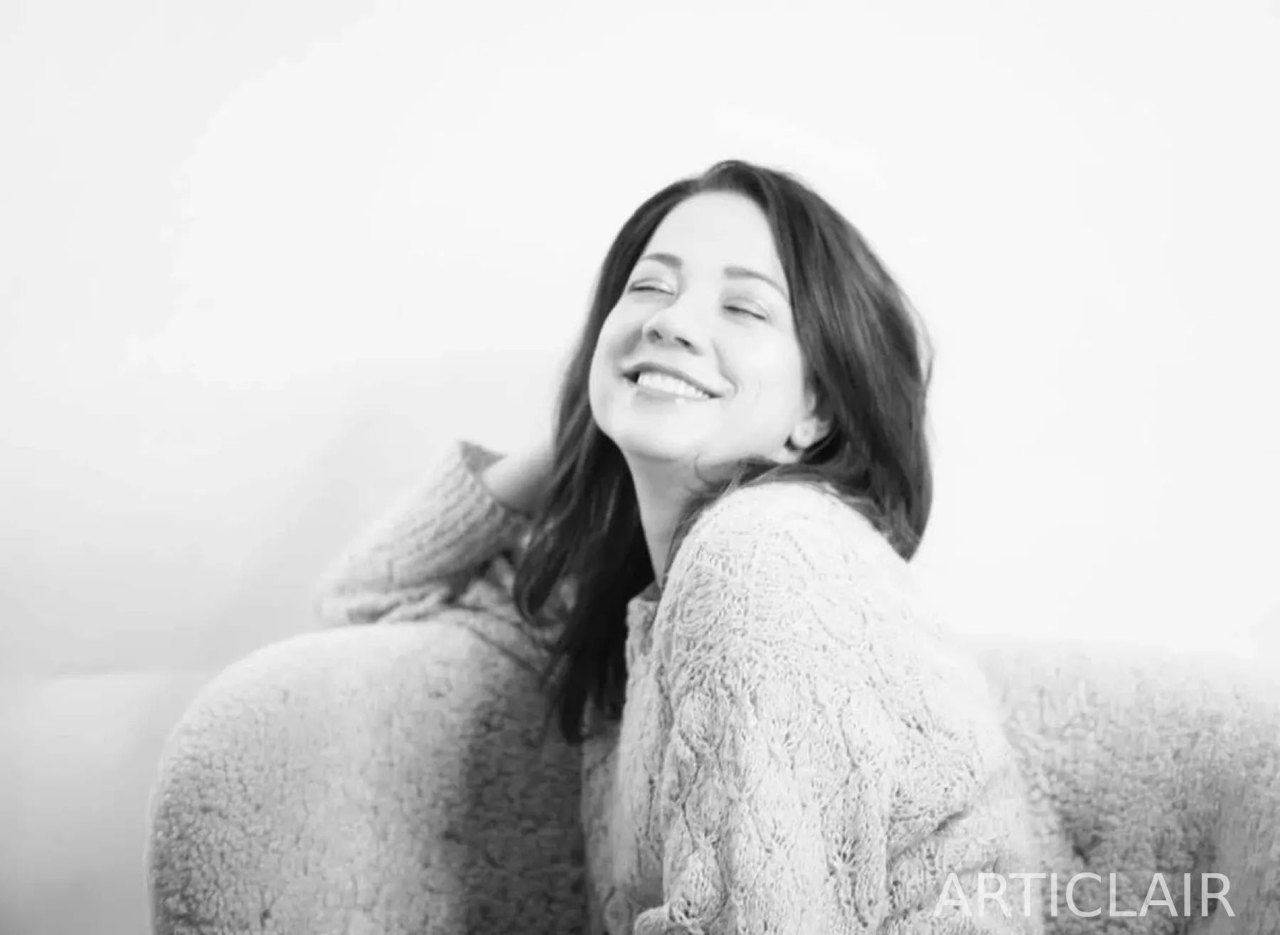 A soft black-and-white portrait with a calm smile