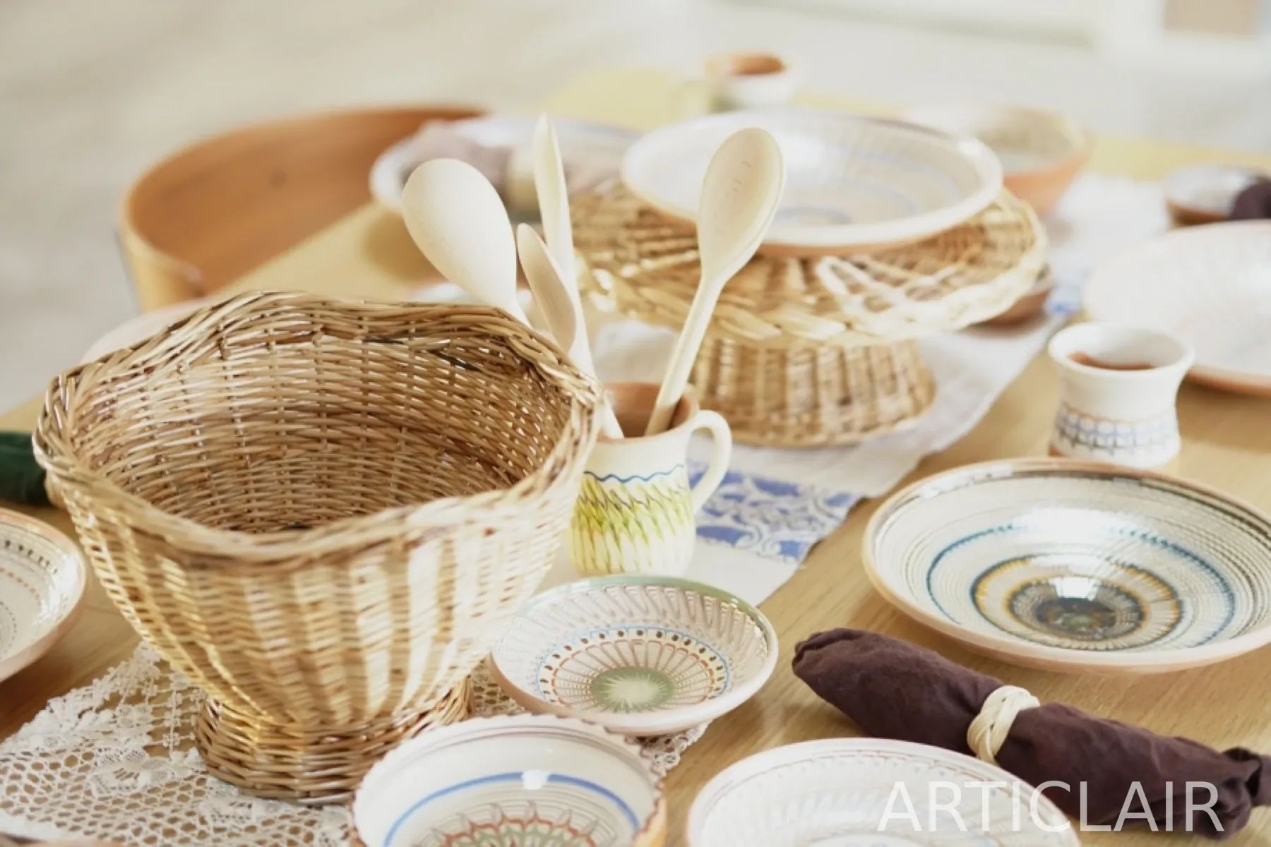 A table setting with woven baskets, wooden spoons, and ceramic bowls